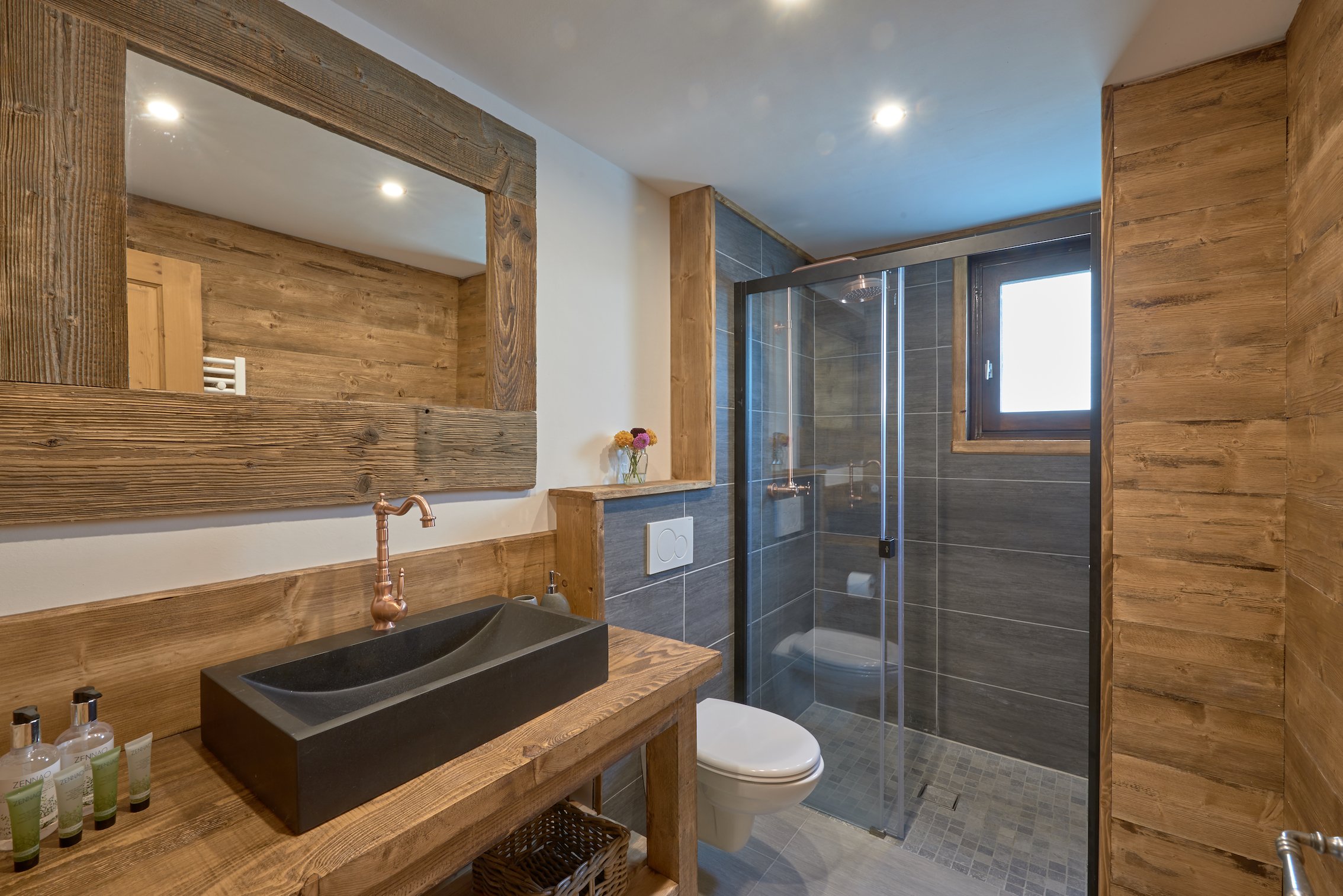 Contemporary chalet bathroom in Les Gets with wooden finishes and glass shower.