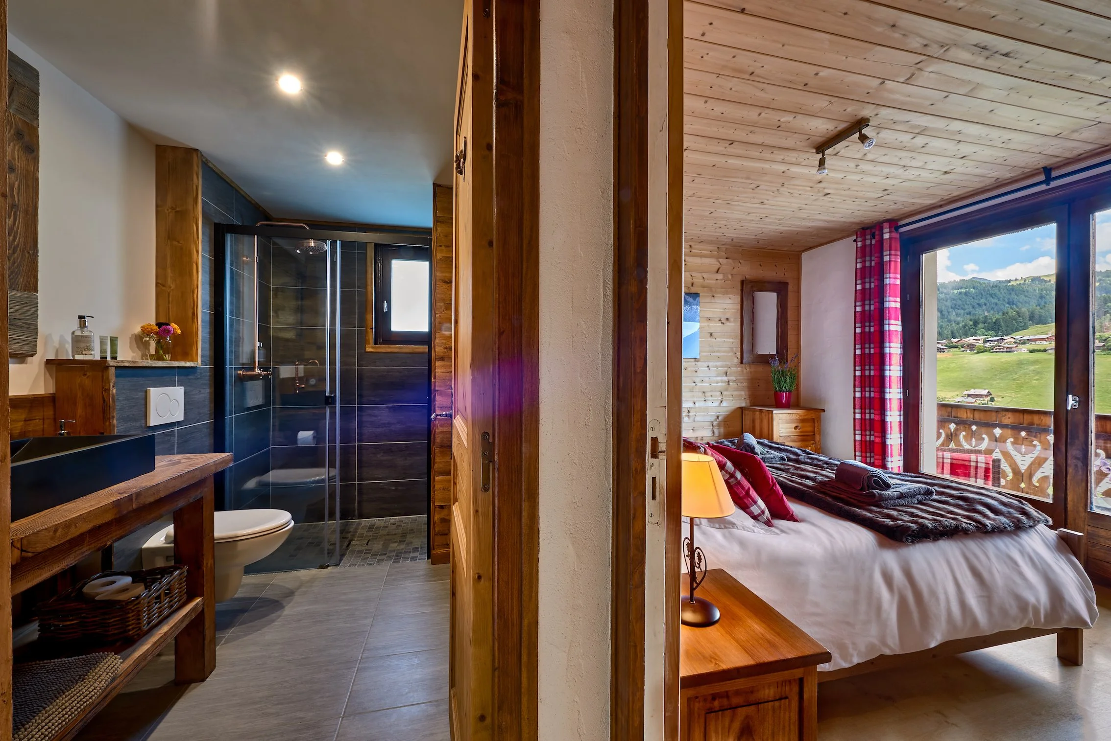 Spacious chalet bedroom with mountain views in Les Gets featuring wooden interiors and modern ensuite bathroom.
