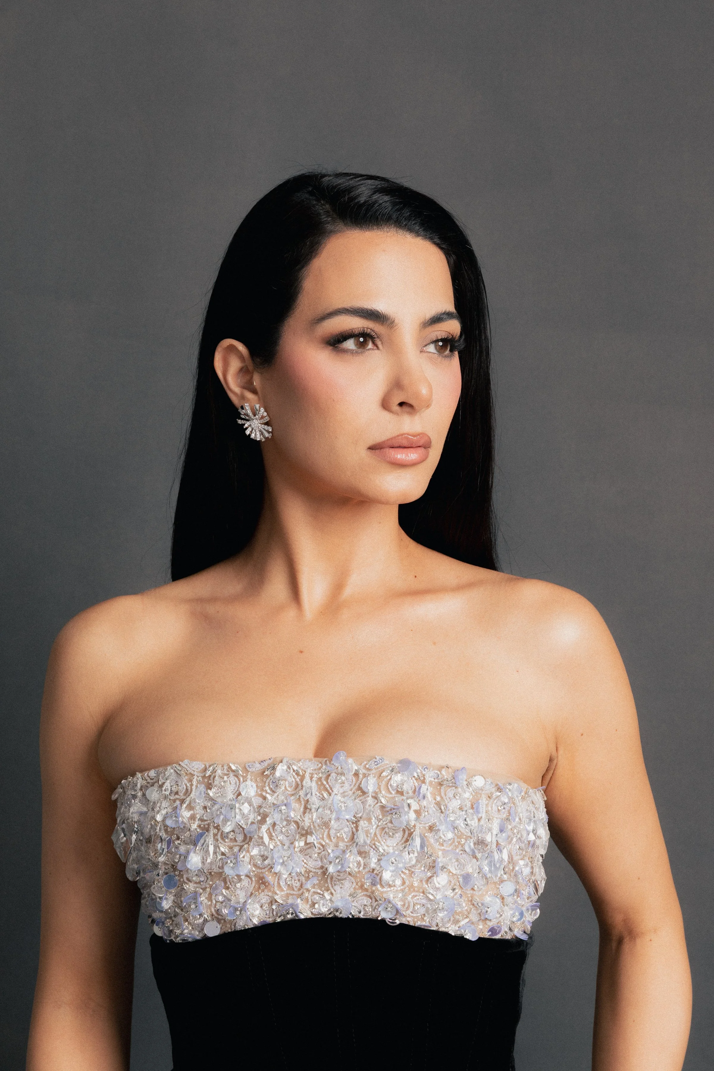 Editorial portrait of Emeraude Toubia in a textured strapless dress, featuring a corset midsection, for the 32nd Annual Actor Awards feature.