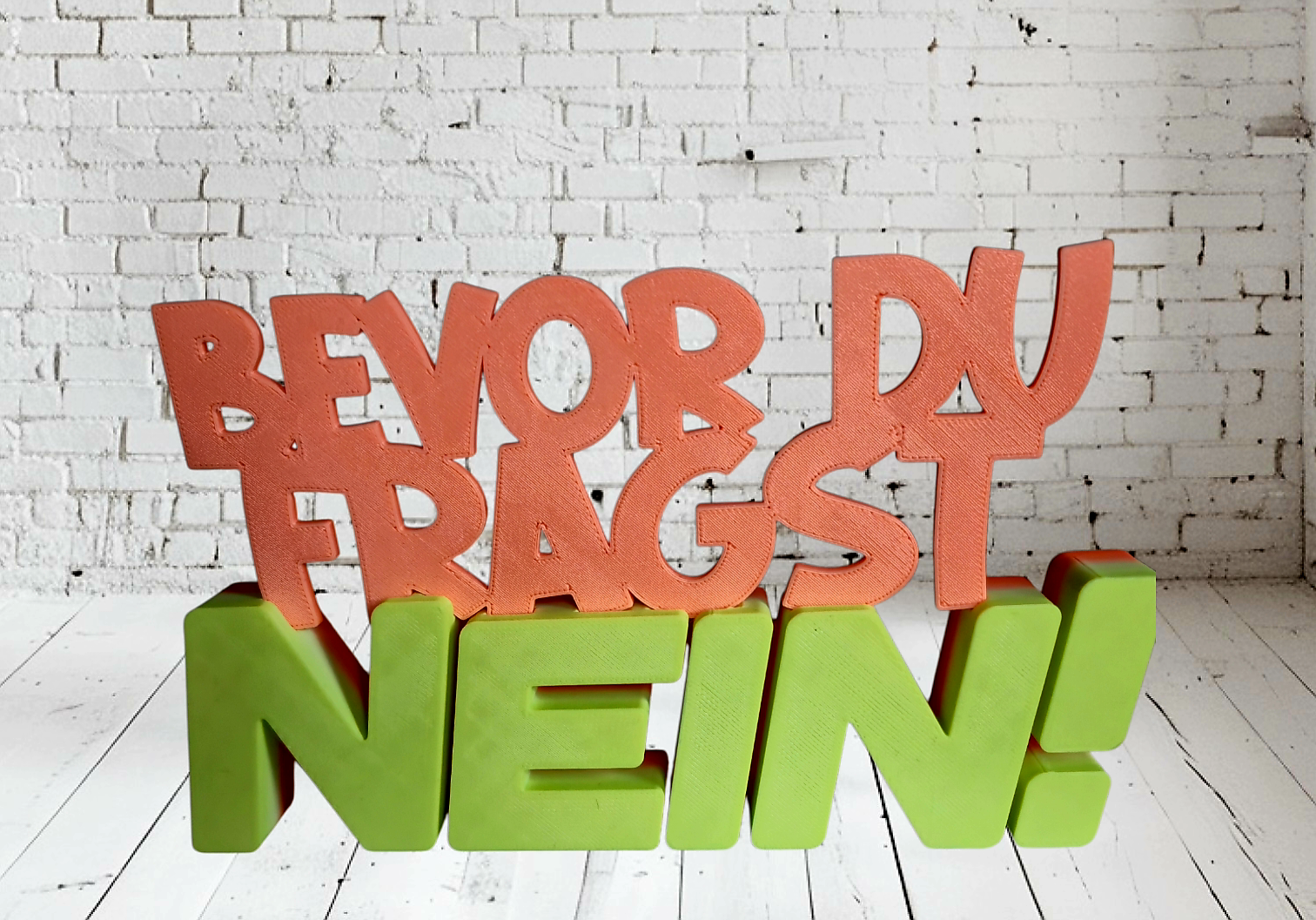 Kreative Wanddekoration mit bunten Buchstaben, die die Wörter 'BEWOR DU FRAUGST NEIN!' in einer modernen Wohnumgebung darstellen.