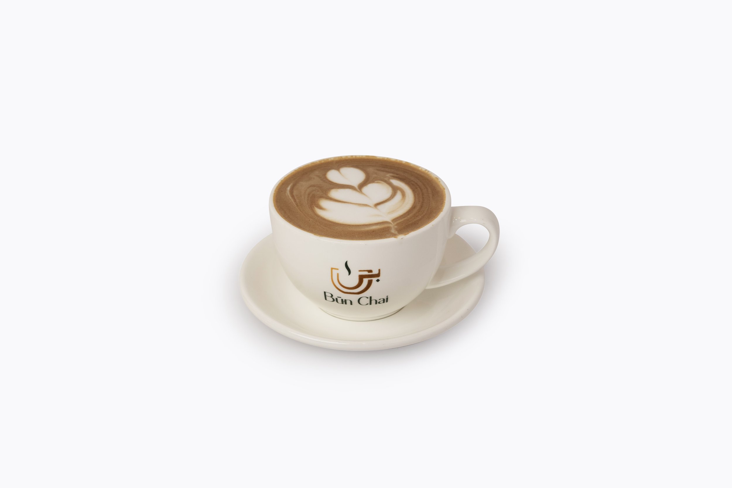 A white coffee cup with a logo on it, filled with a latte that has latte art on top, sitting on a white saucer against a plain white background.