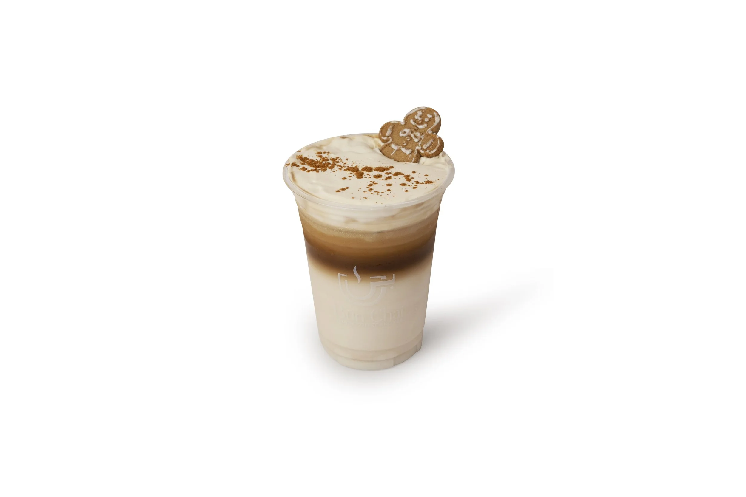 A layered iced coffee drink topped with whipped cream, a gingerbread cookie, and a sprinkle of cinnamon.