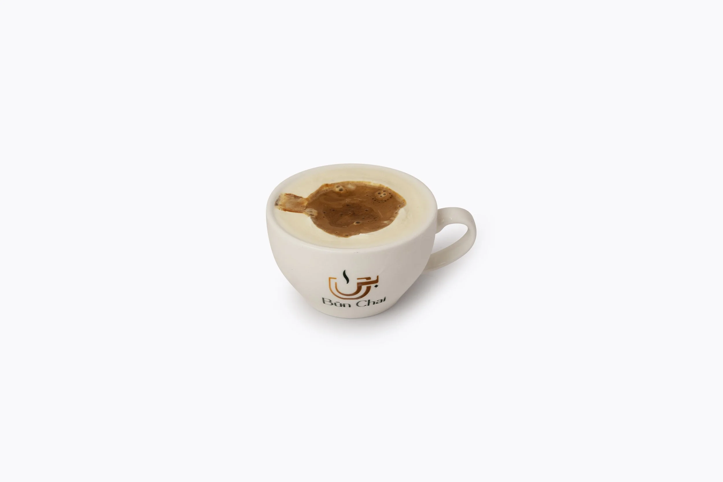 A white coffee mug labeled "Bun Chai" with a logo, filled with tea topped with milk foam, on a plain white background.