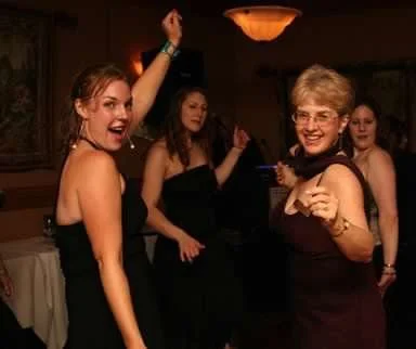 Group of women dancing and having fun at a party in an indoor setting.