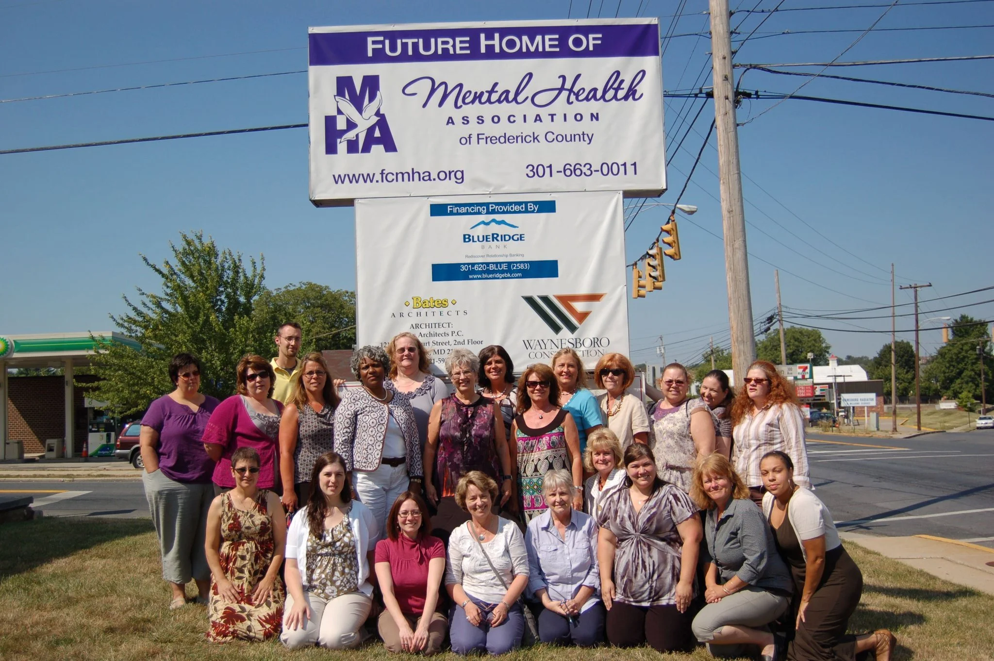 MHA employees pose in front of the MHA sign on Jefferson street, Frederick