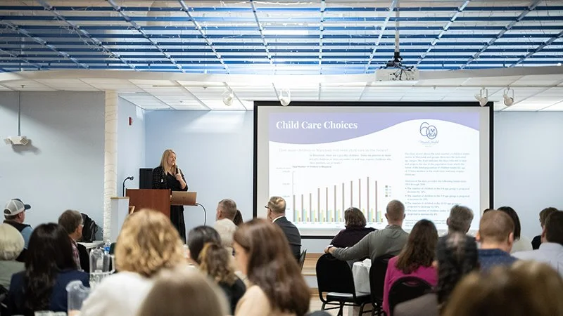 A woman giving a presentation about child care choices at a conference at the MHA Speakers Bureau
