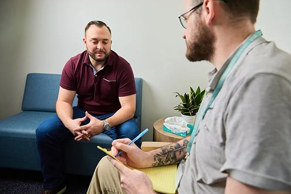 two men sit in a psychologists office discussing, MHA staff has tattoos