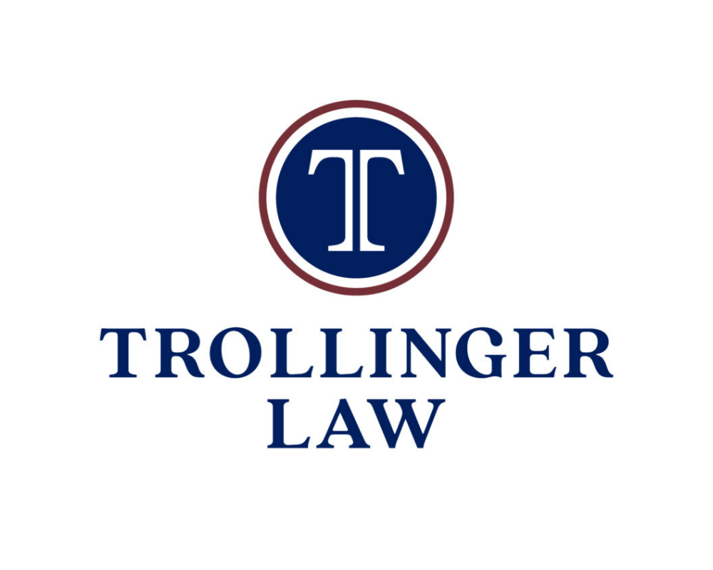 Logo with a navy blue circle containing a white stylized 'T', surrounded by a maroon ring, with the words 'TROLLINGER LAW' in bold navy blue text below.