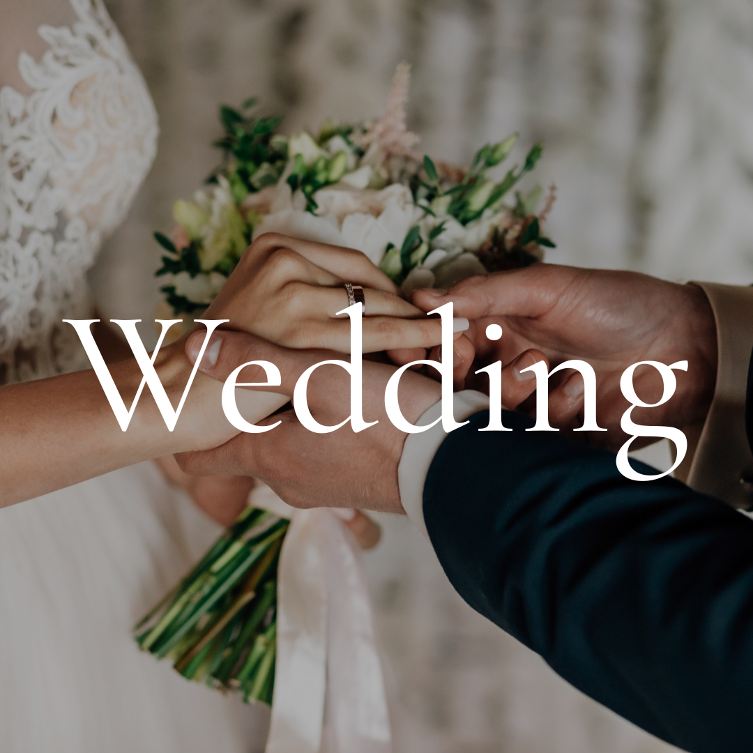 Close-up of a bride and groom holding hands during a wedding ceremony, with the bride's bouquet in the background.
