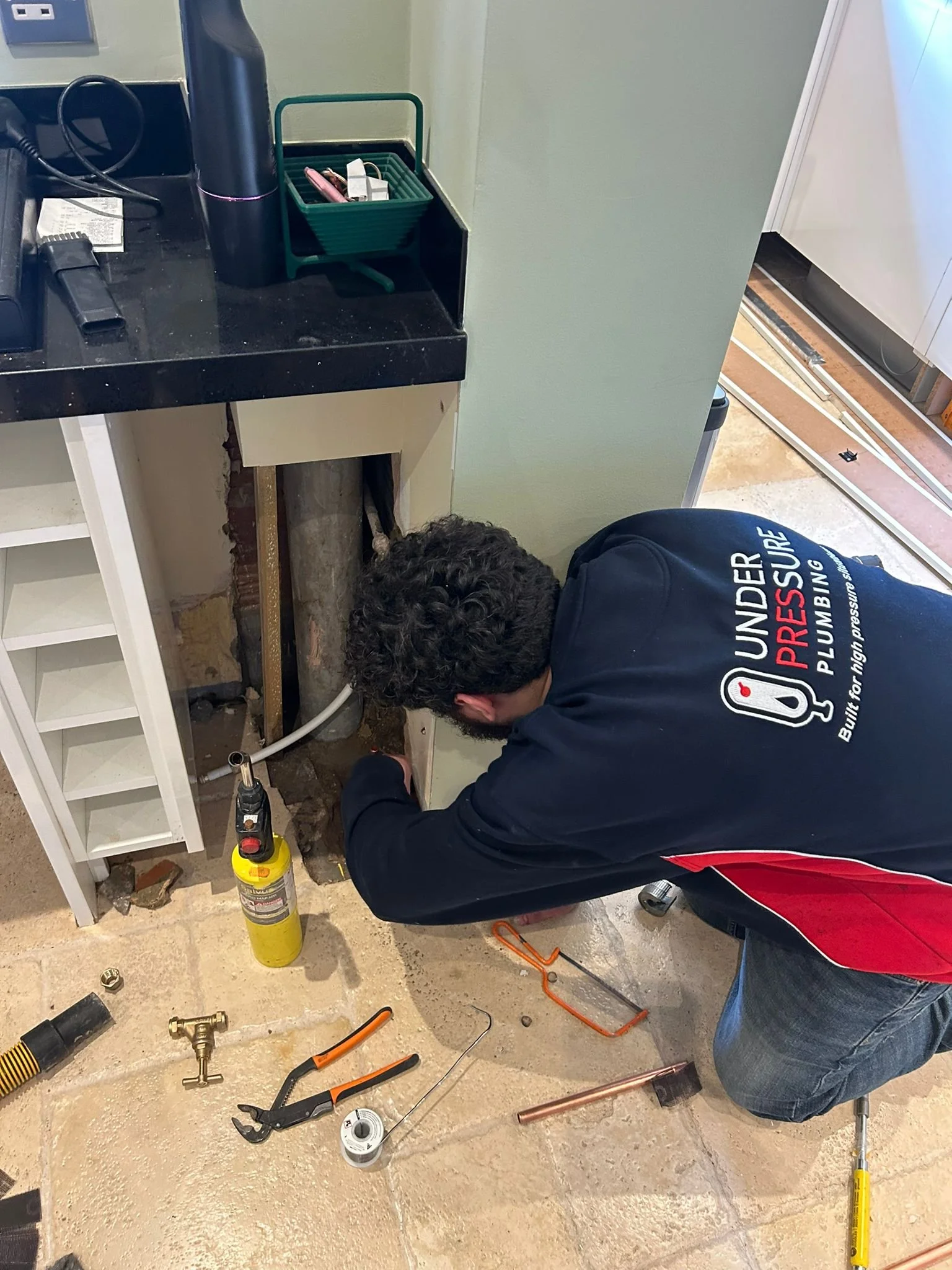Under Pressure Plumbing engineer carrying out plumbing repairs at a home in East London.