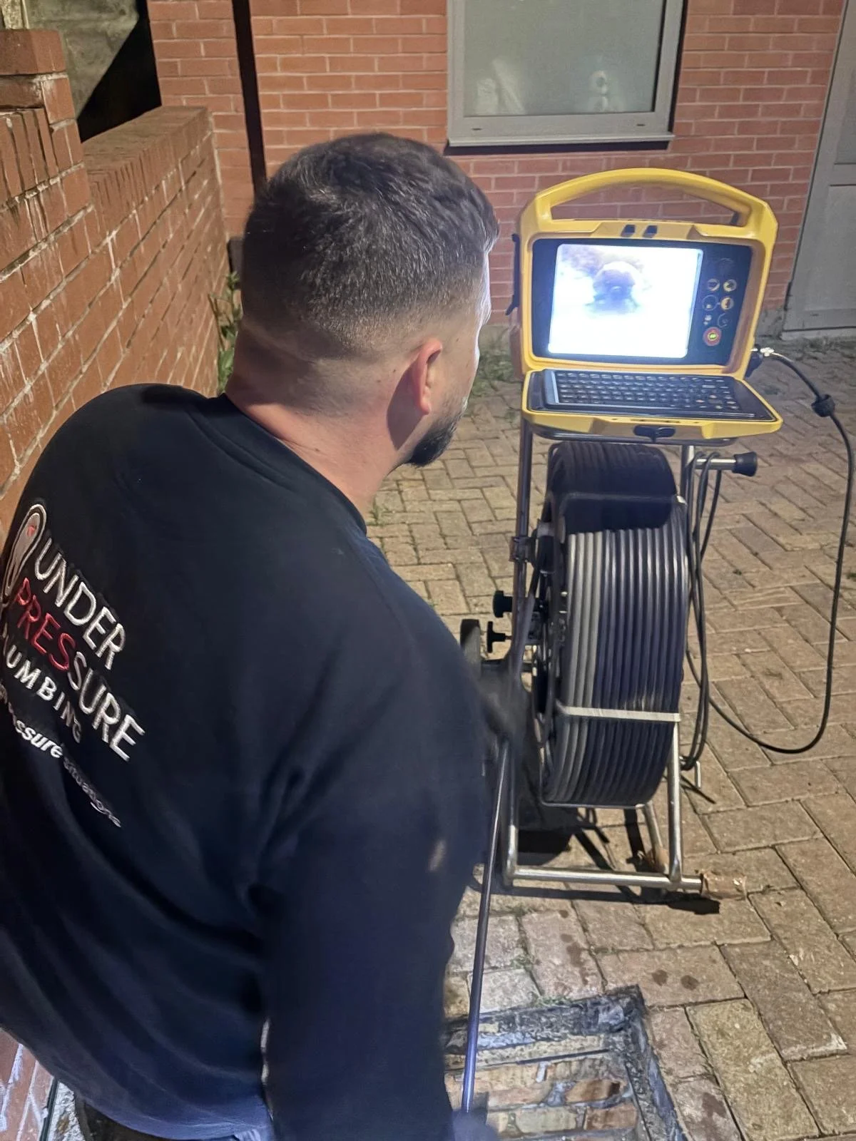 Under Pressure Plumbing engineer using CCTV drain inspection equipment to diagnose a blocked drain in North London.