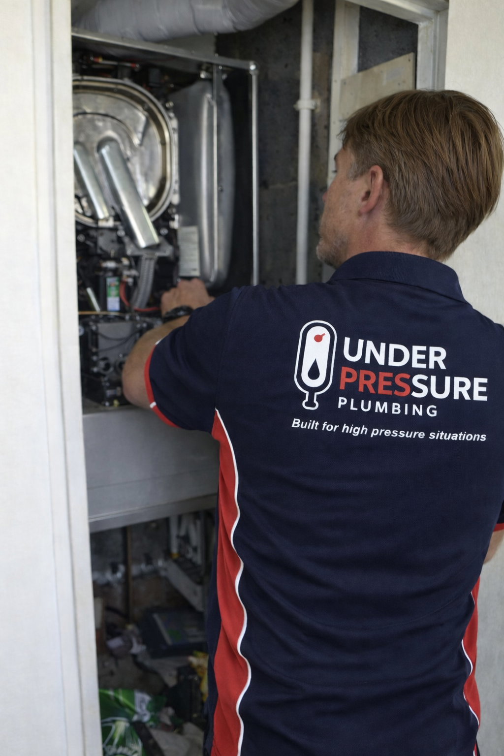 Engineer repairing boiler and heating system in London home