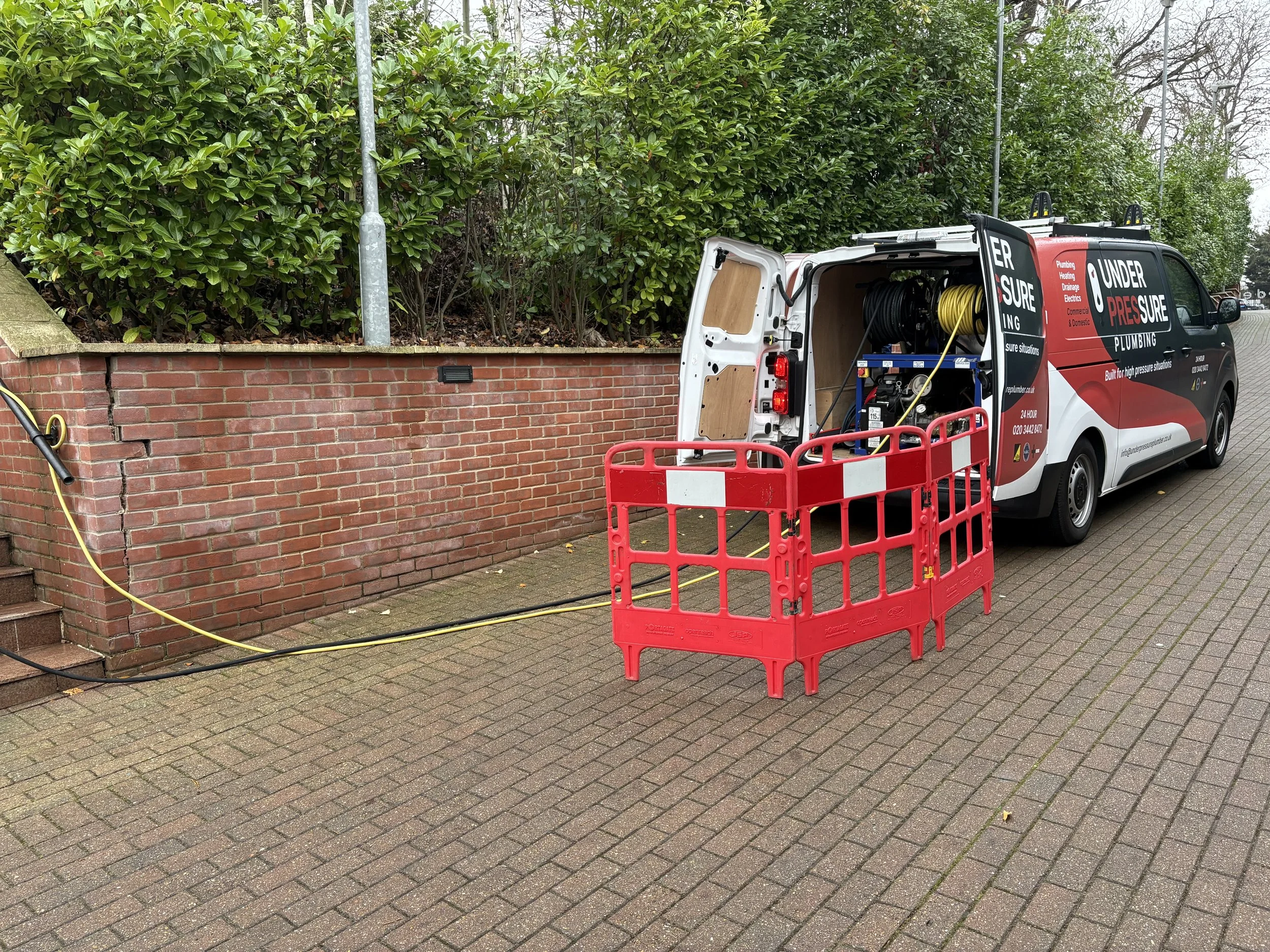 Engineer carrying out blocked drain clearance using professional drainage equipment in London.