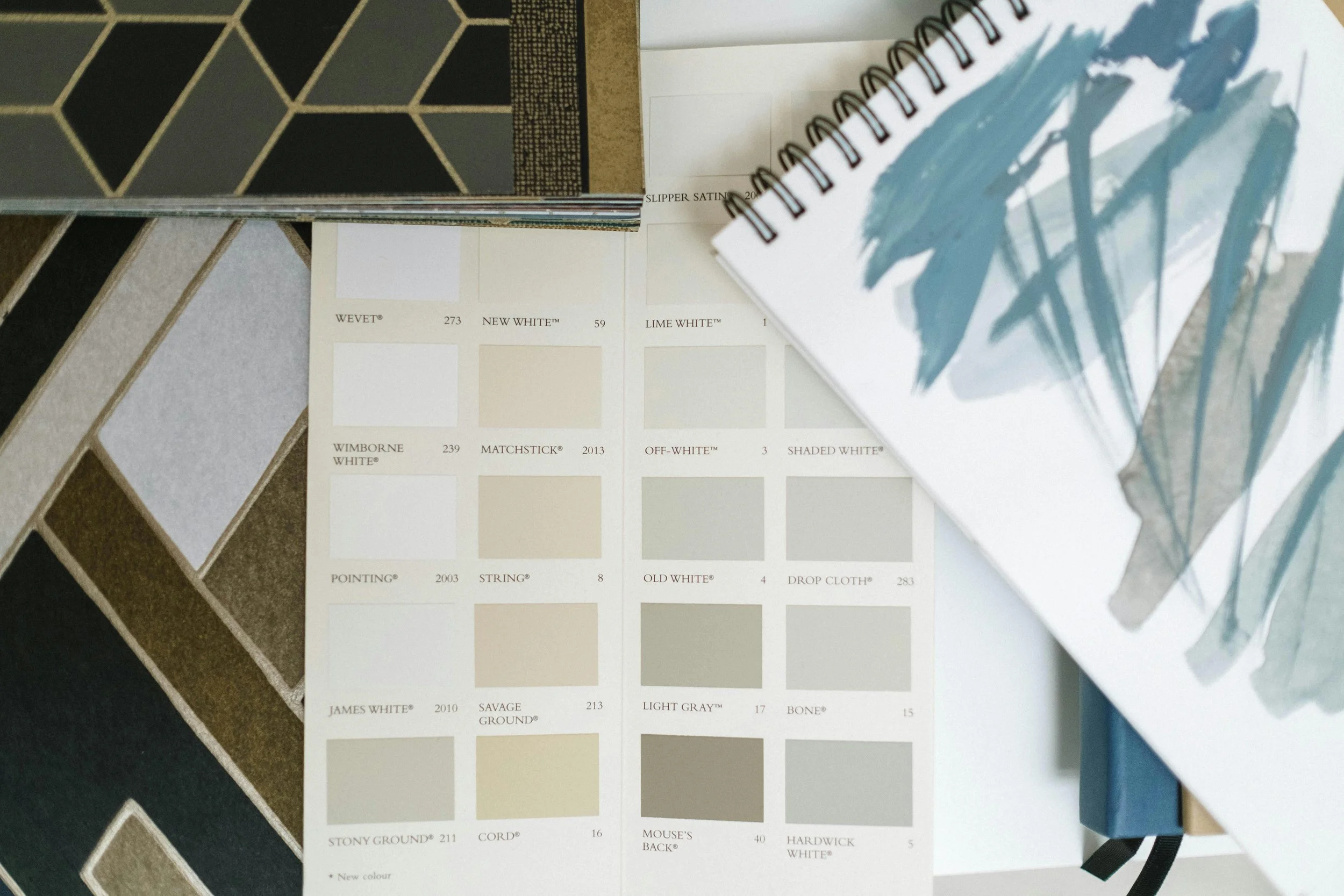 A color swatch sample book showing various shades of beige, white, gray, and cream, along with textured samples and paint color codes. Some of the visible color names include WETW, NEW WHITE, LIME WHITE, WIMBORNE WHITE, MATCHSTICK, OFF-WHITE, SHADED WHITE, JAMES WHITE, SAVAGE GROUND, LIGHT GRAY, BONE, STONY GROUND, CORD, MOUSE'S BACK, and HARDWICK WHITE.