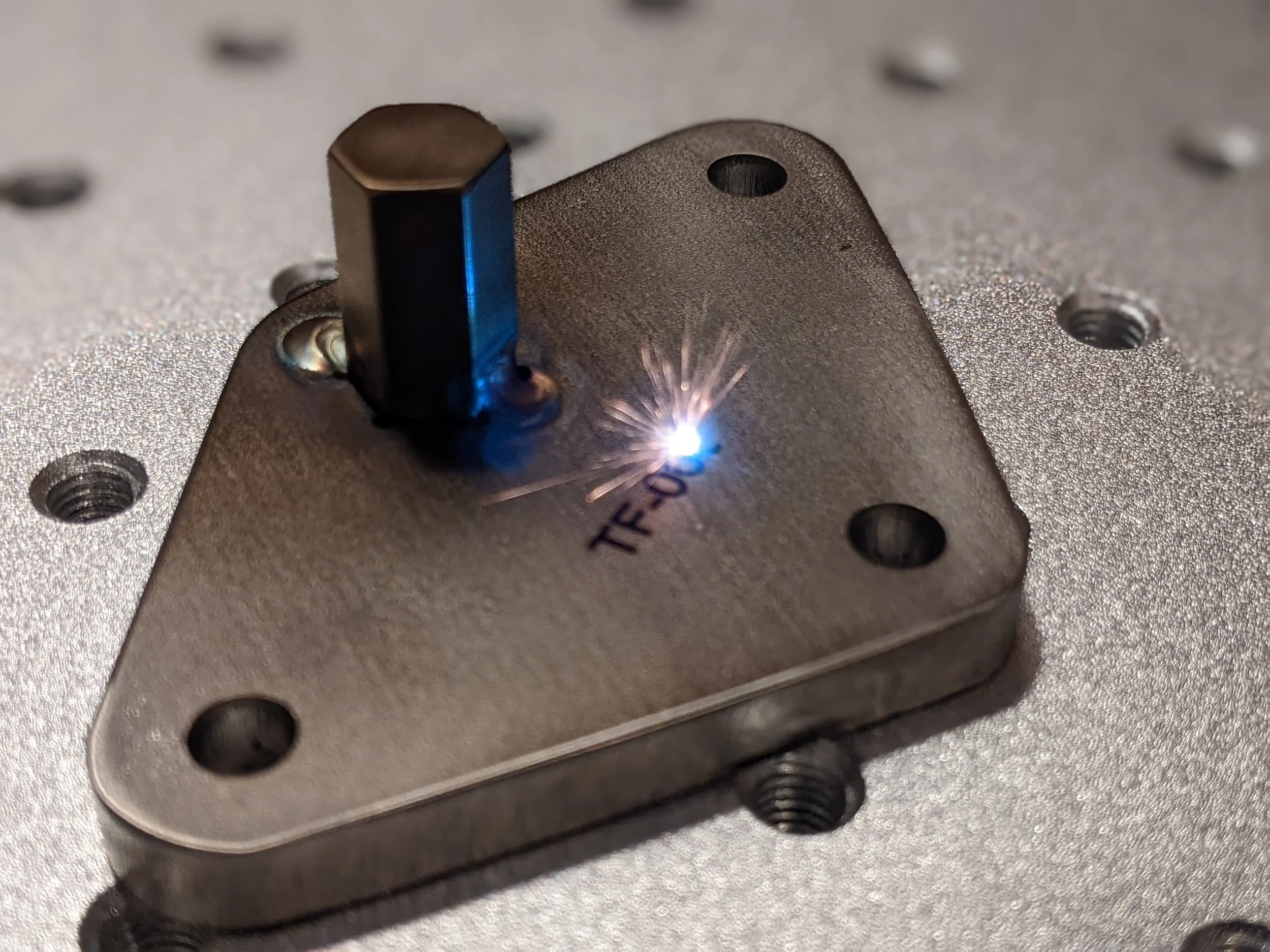 Fiber laser part marking this stainless steel test fixture component.