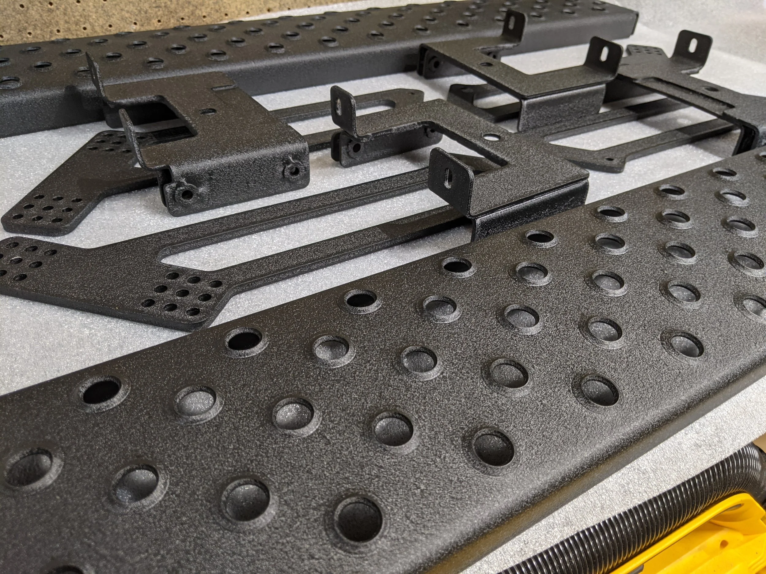 Laser cut and bent blanks were procured then TIG welding and dimple die forming were performed in house. Powder coated to match factory accessory appearance on customer's vehicle.