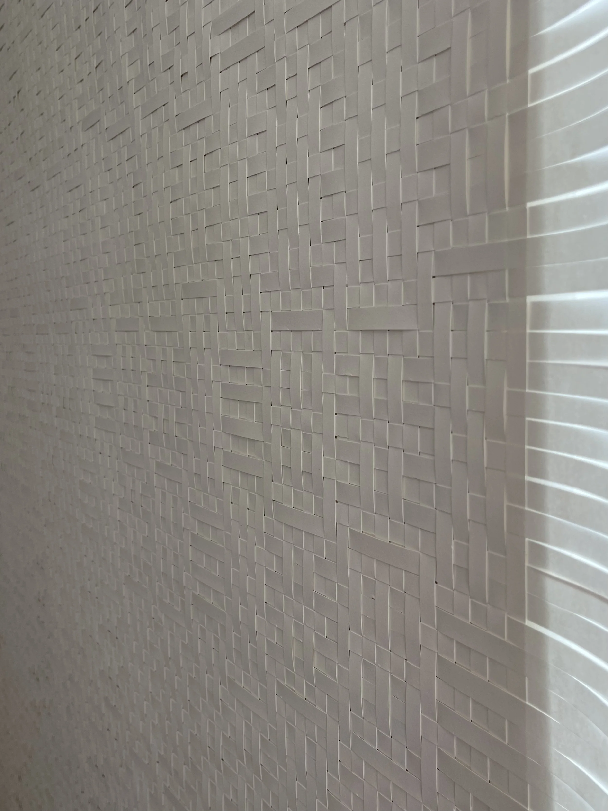 Close-up of a detailed white textured wall with a geometric pattern of small rectangles and lines.