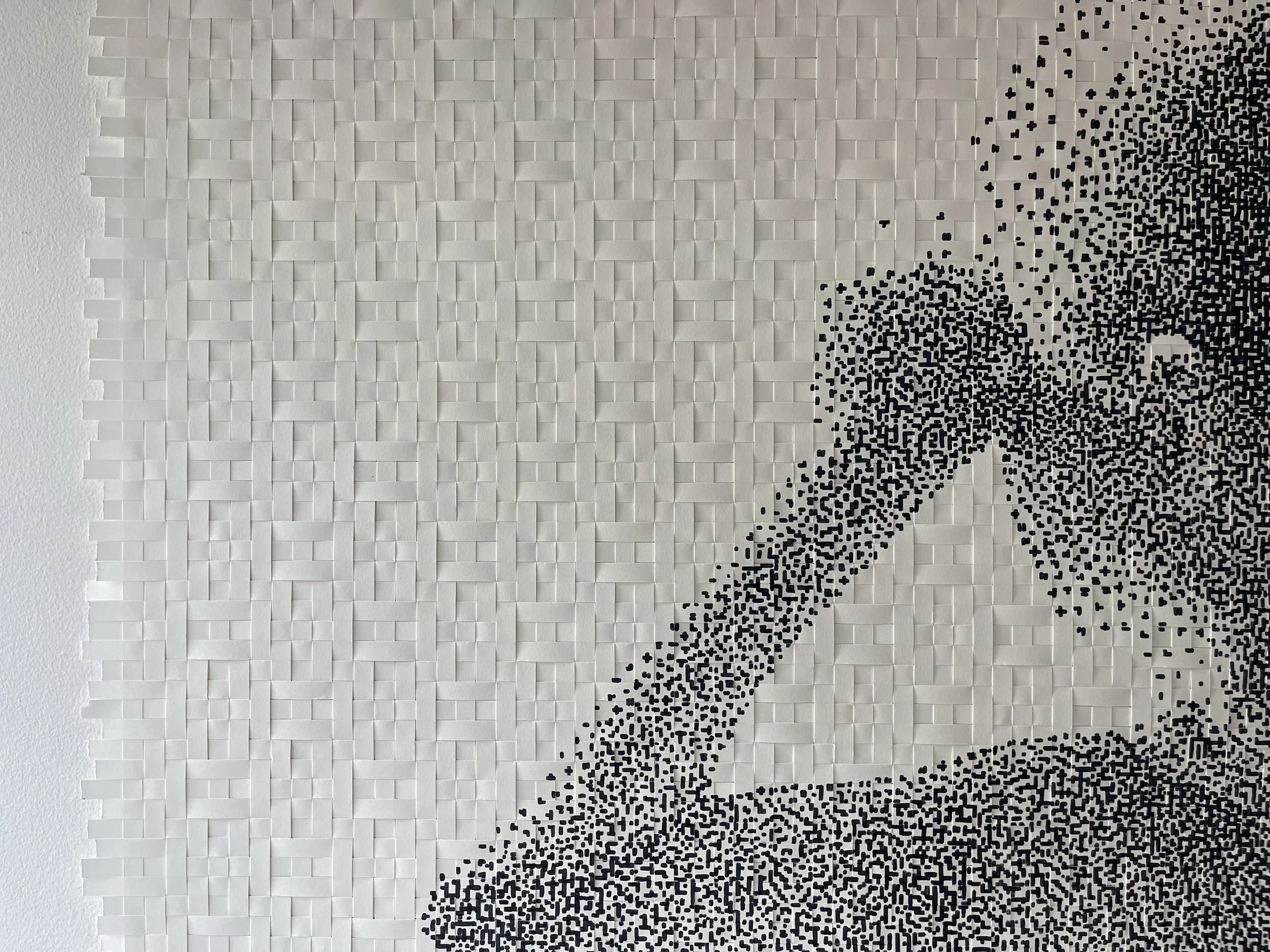 A wall with 3D white tiles and a mosaic of a person in black and white on the right side.