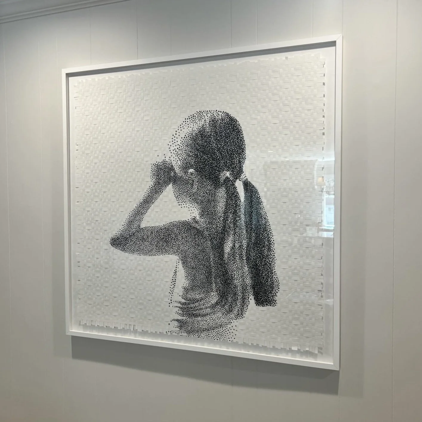 Pointillism artwork of a girl with long hair covering her eye, touching her ear.