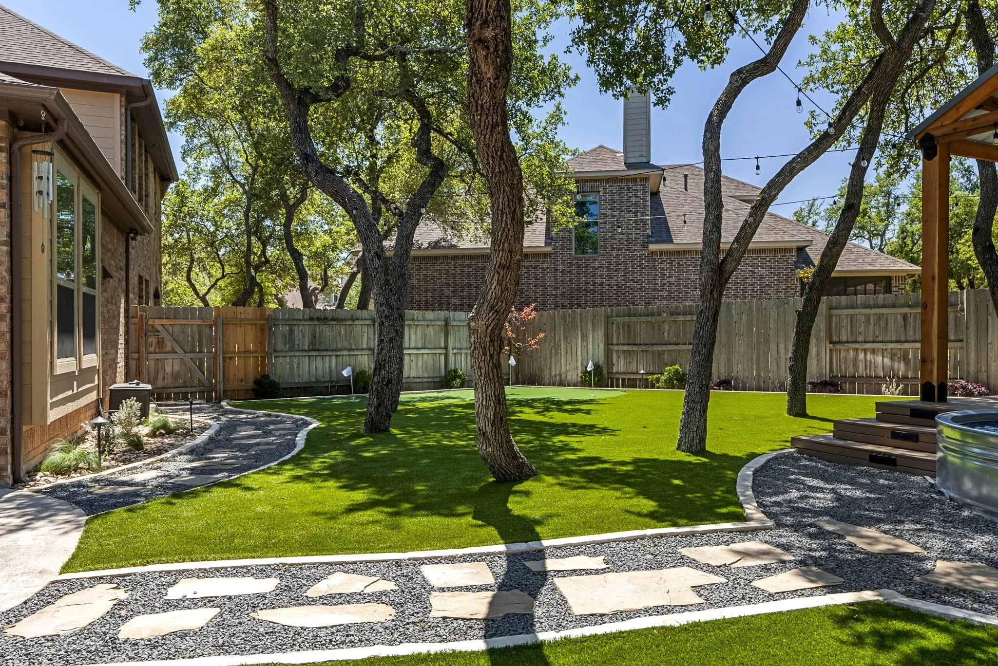 Backyard landscape transformation with putting green and low-maintenance planting beds — Southern Love