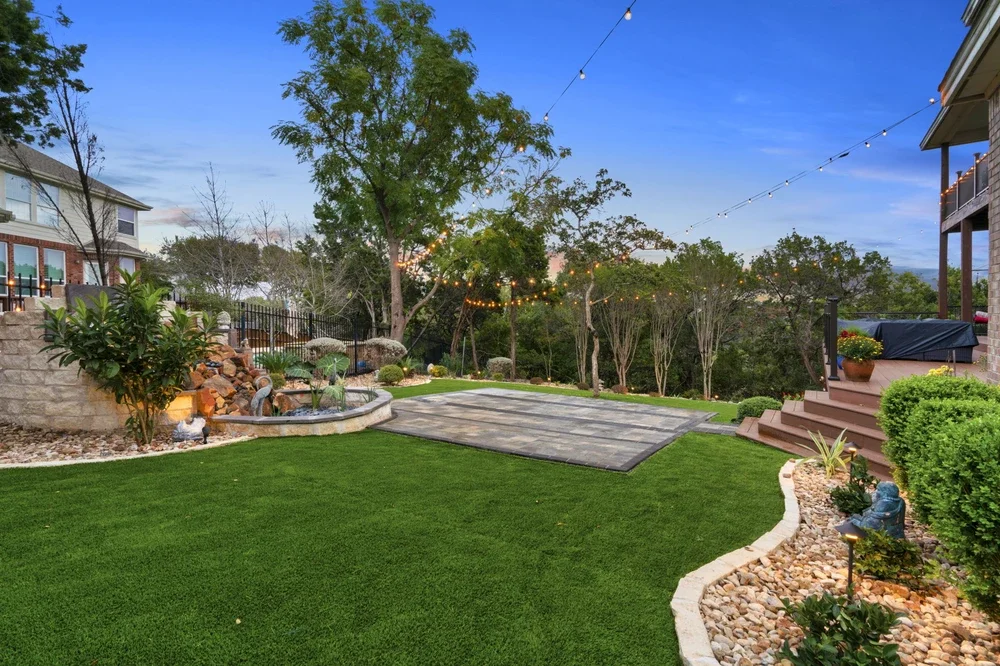 Fully cleaned and landscaped yard with lighting and decor, showcasing the results of a thorough Austin yard clean-up.
