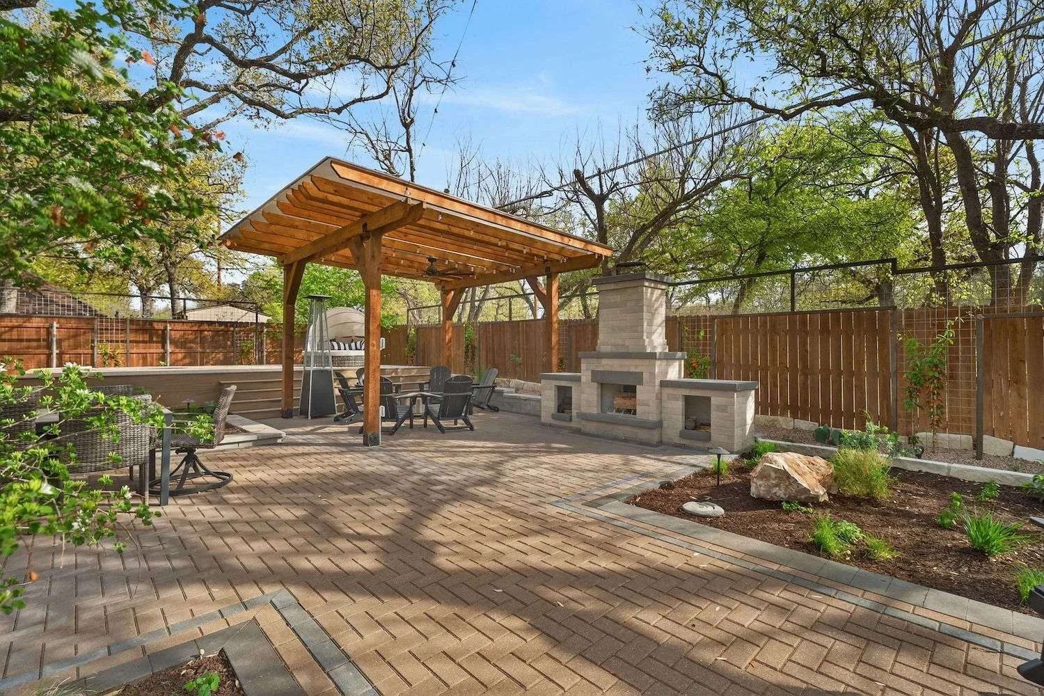 Paver patio installation with pergola, fire pit, and outdoor living space design in Austin, TX
