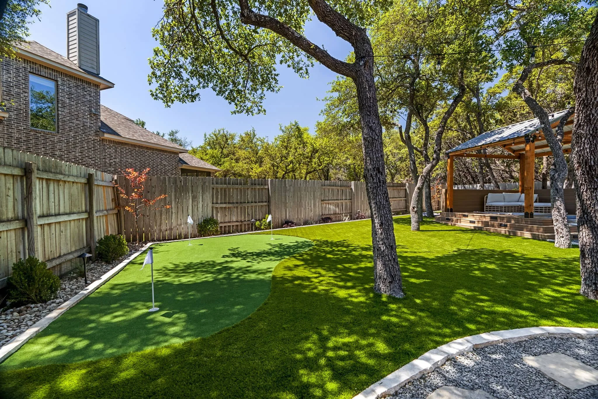 Backyard outdoor living project with low-maintenance landscape beds and putting green — Southern Love