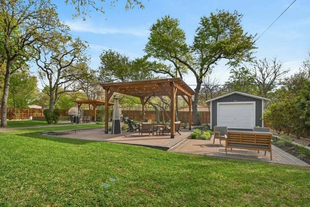 Backyard with two cedar pergolas, paver patios and lawn under mature oak trees — Southern Love Landscaping & Design
