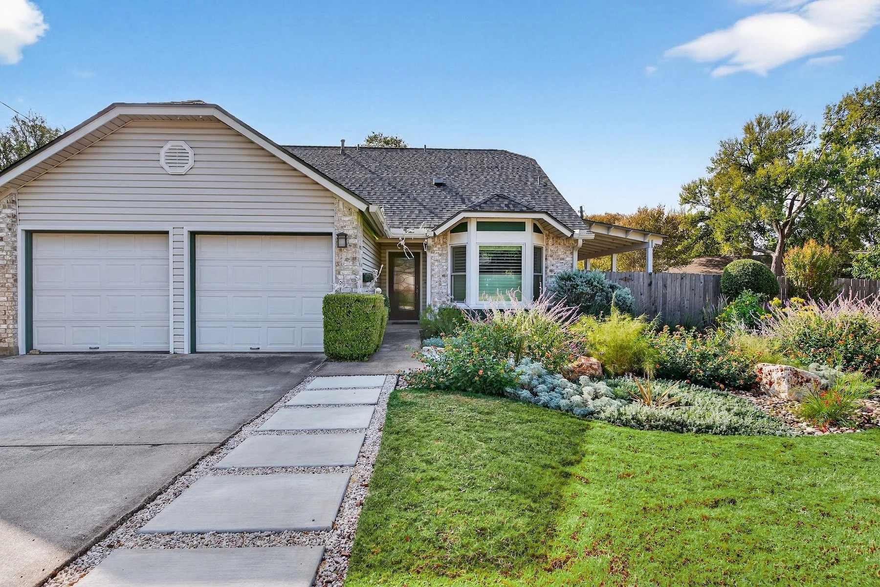 Ranch home entry with concrete paver walkway, lawn, and perennial bed of silver artemisia and salvia