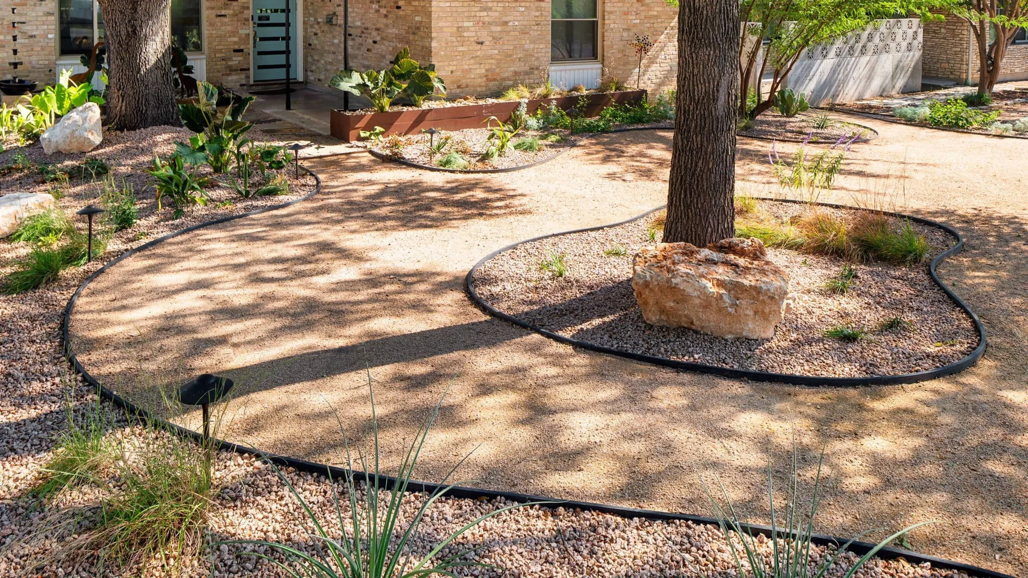 Landscape installation featuring gravel pathways and layered front foundation planting — Southern Love