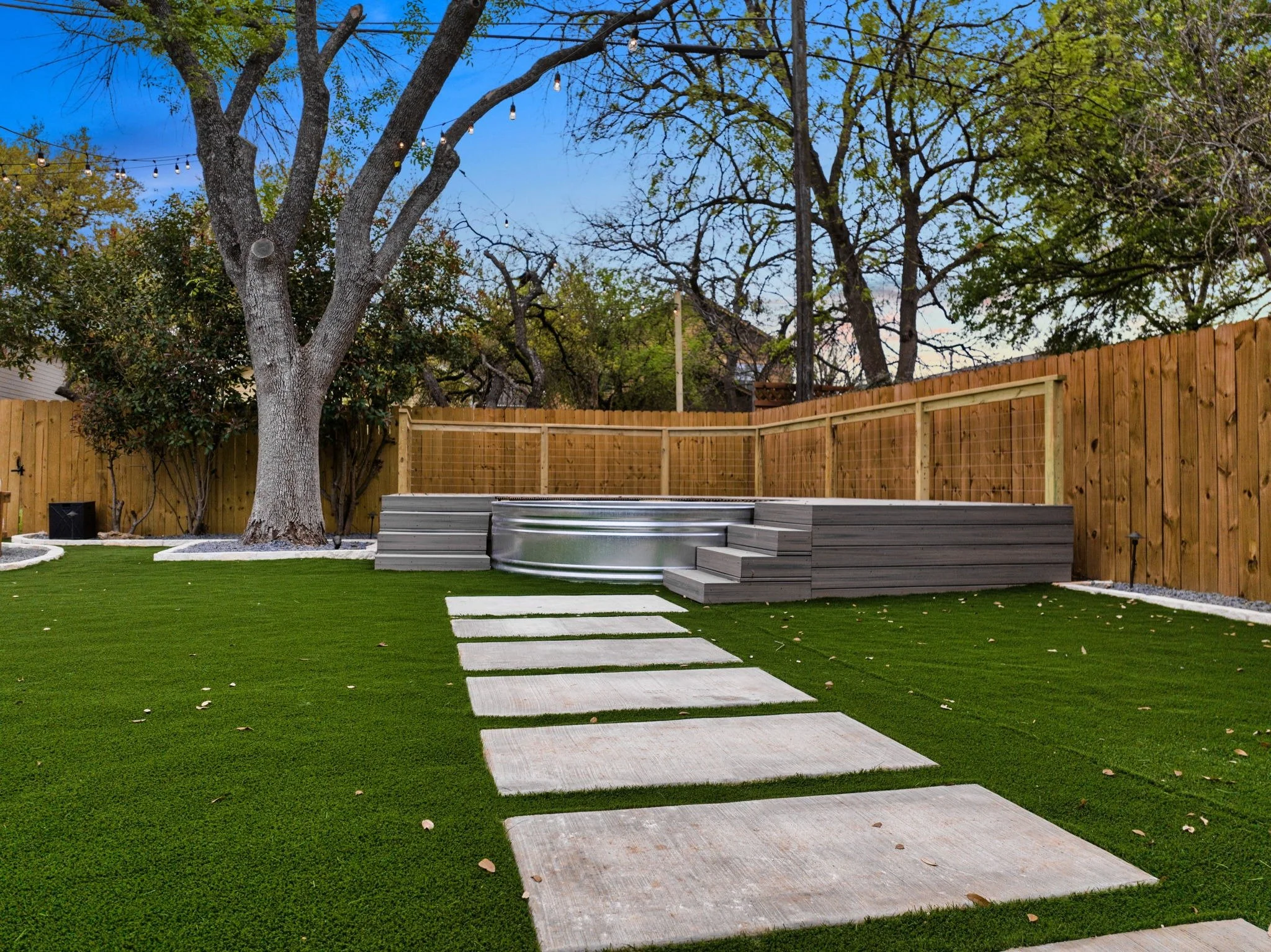 A pool deck on top of a green lawn.