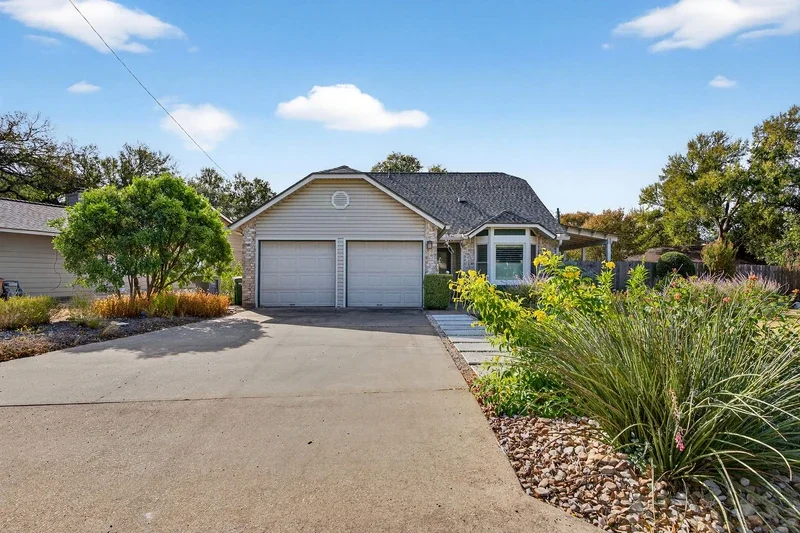Front yard hardscaping with low-maintenance plants and a wide concrete driveway, great for January curb appeal updates.