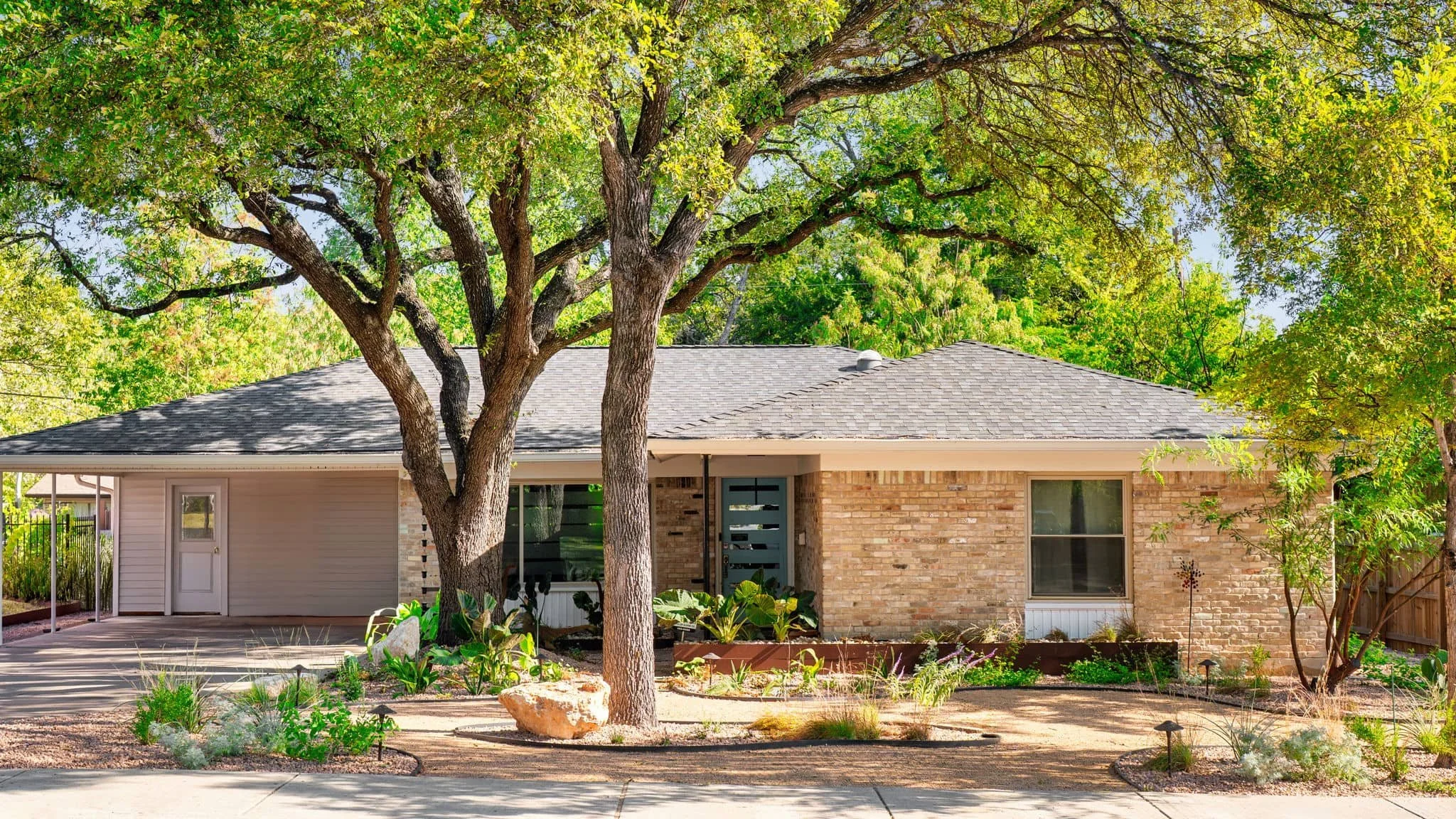 Modern front yard landscaping with gravel beds and layered foundation planting — Southern Love