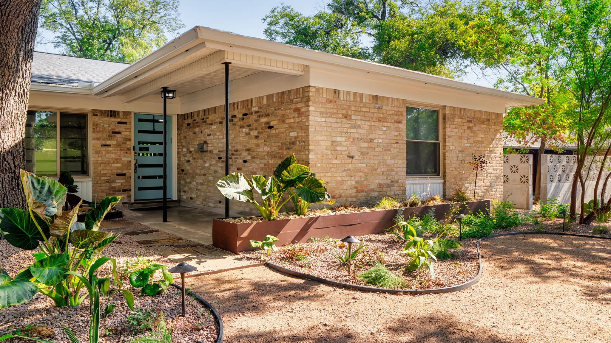 Low-maintenance front landscaping with steel edging and natural texture elements — Southern Love