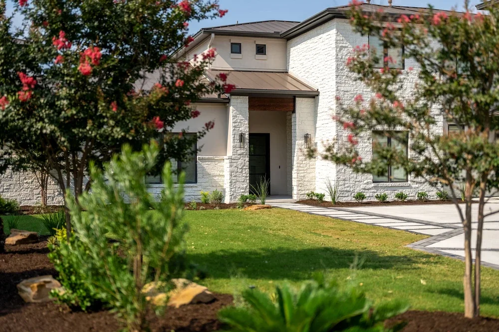 Front yard landscaping with drought-tolerant plantings adapted to Austin soil and terrain.