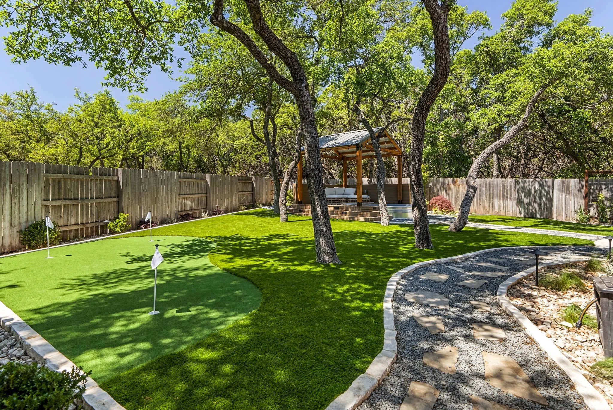 Resort-style outdoor living space with covered patio and low-maintenance landscaping design — Southern Love