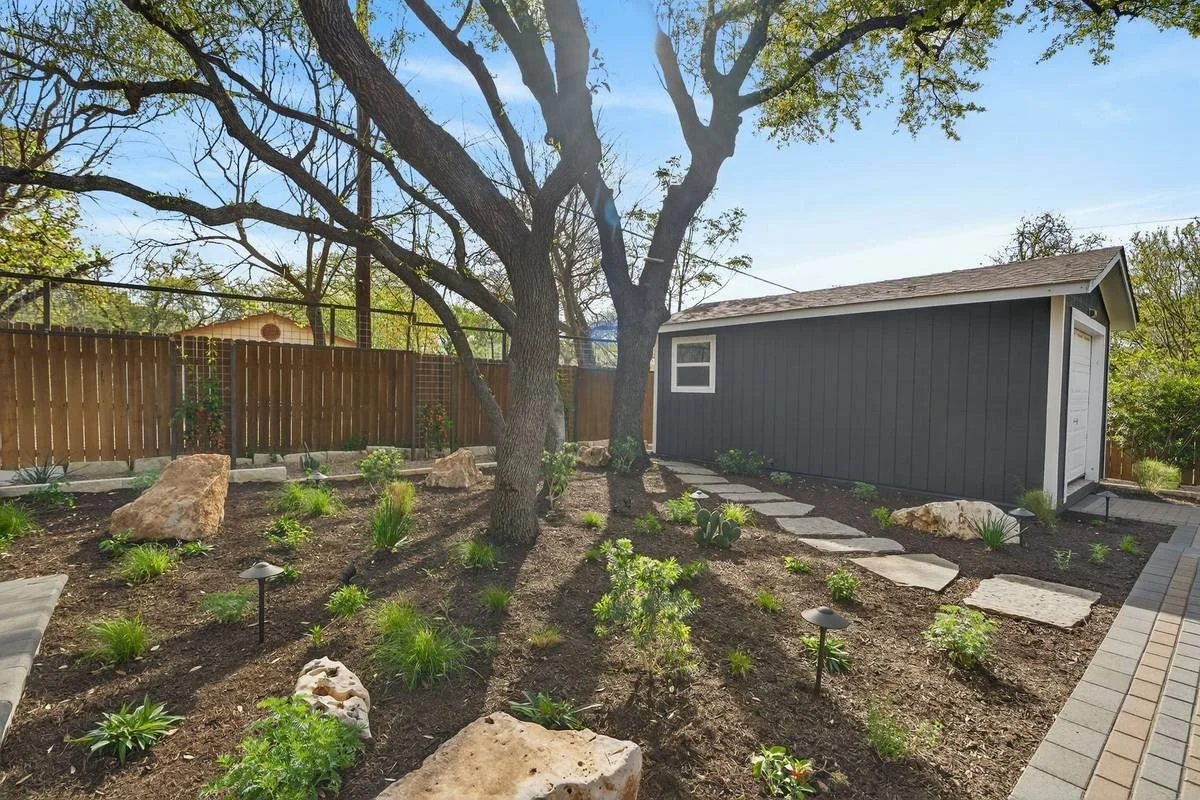 Planting bed with limestone boulders, path lights and stepping stones — Southern Love Landscaping & Design