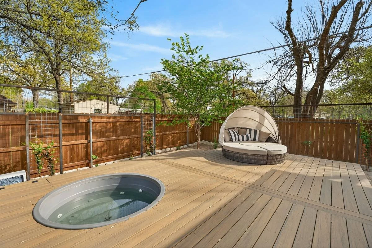 Stock-tank plunge pool set flush in a raised composite deck beside a daybed — Southern Love Landscaping & Design