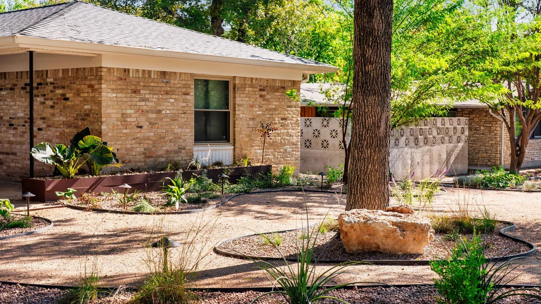 Front home landscaping designed to soften brick architecture with layered plants — Southern Love