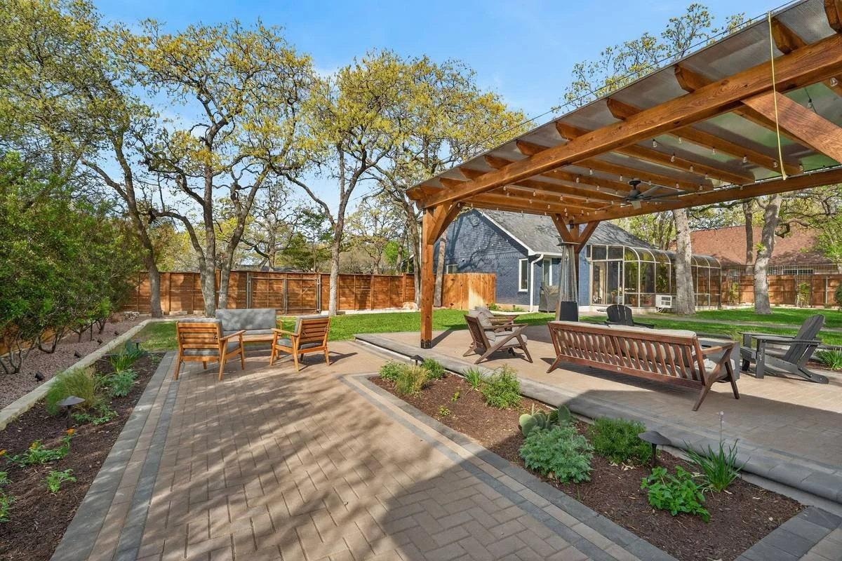 Cedar pergola and a second wood seating area on a herringbone paver patio — Southern Love Landscaping & Design