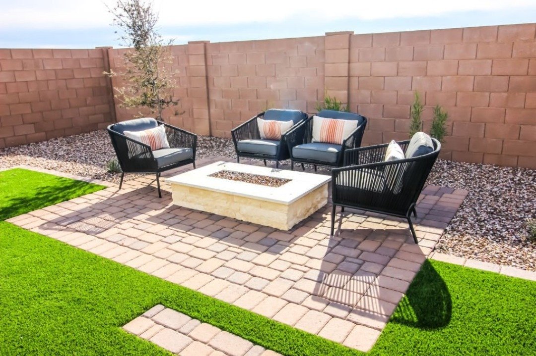 A gorgeous firepit and a paver patio along with a cozy furniture set.
