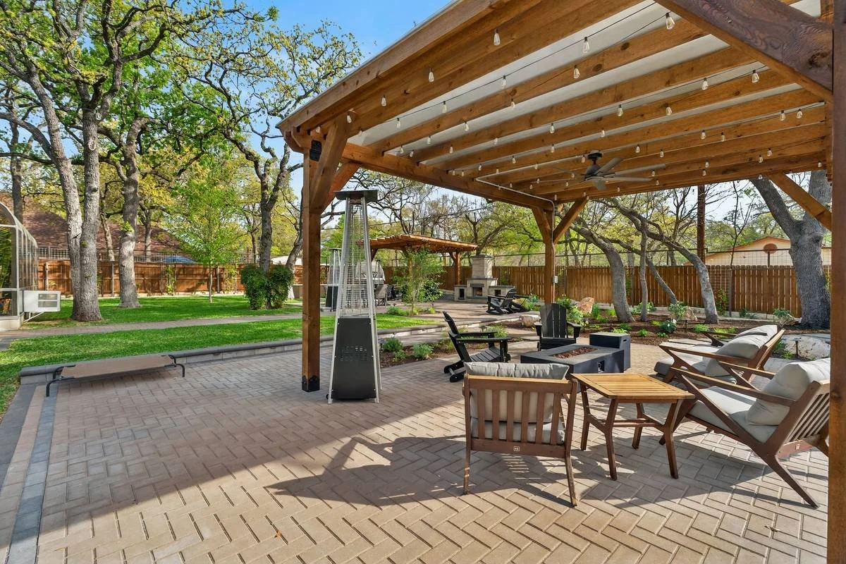 View from the pergola lounge across the patio to the dining pergola and fireplace — Southern Love Landscaping & Design