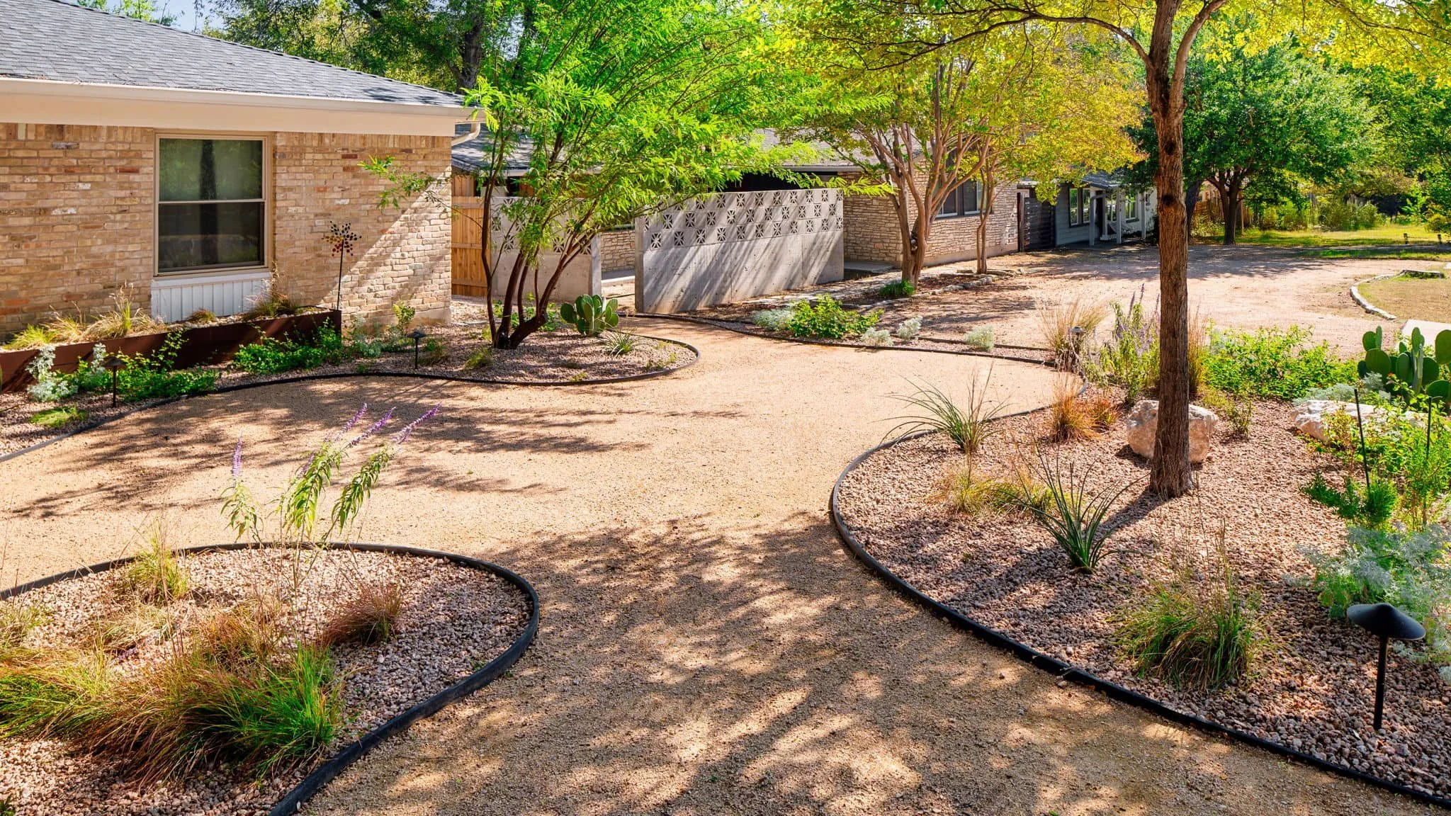 Low-maintenance landscaping with mature trees, gravel accents, and wood fencing — Southern Love