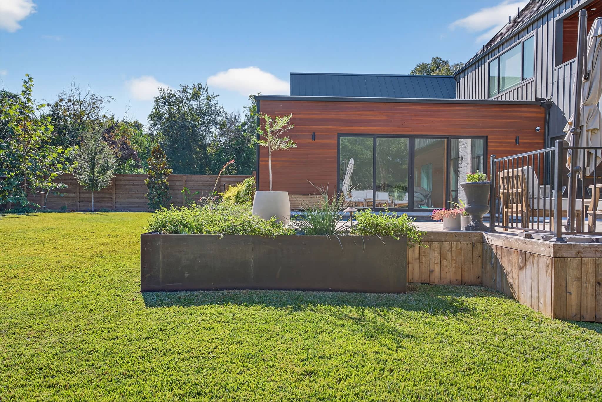 Modern residential landscaping with clean edges, native-style plants, and wood fencing — Southern Love