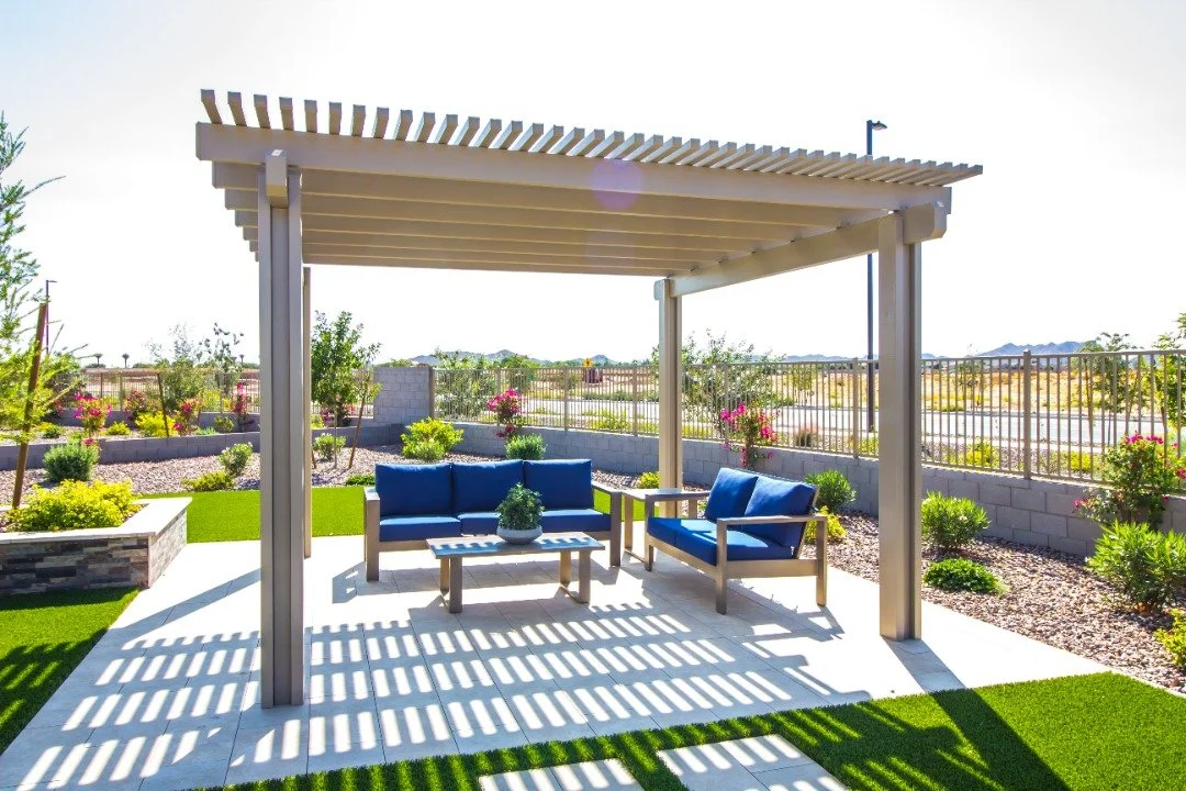 Modern pergola with blue furniture and clean lines, set in a minimalist landscape design.