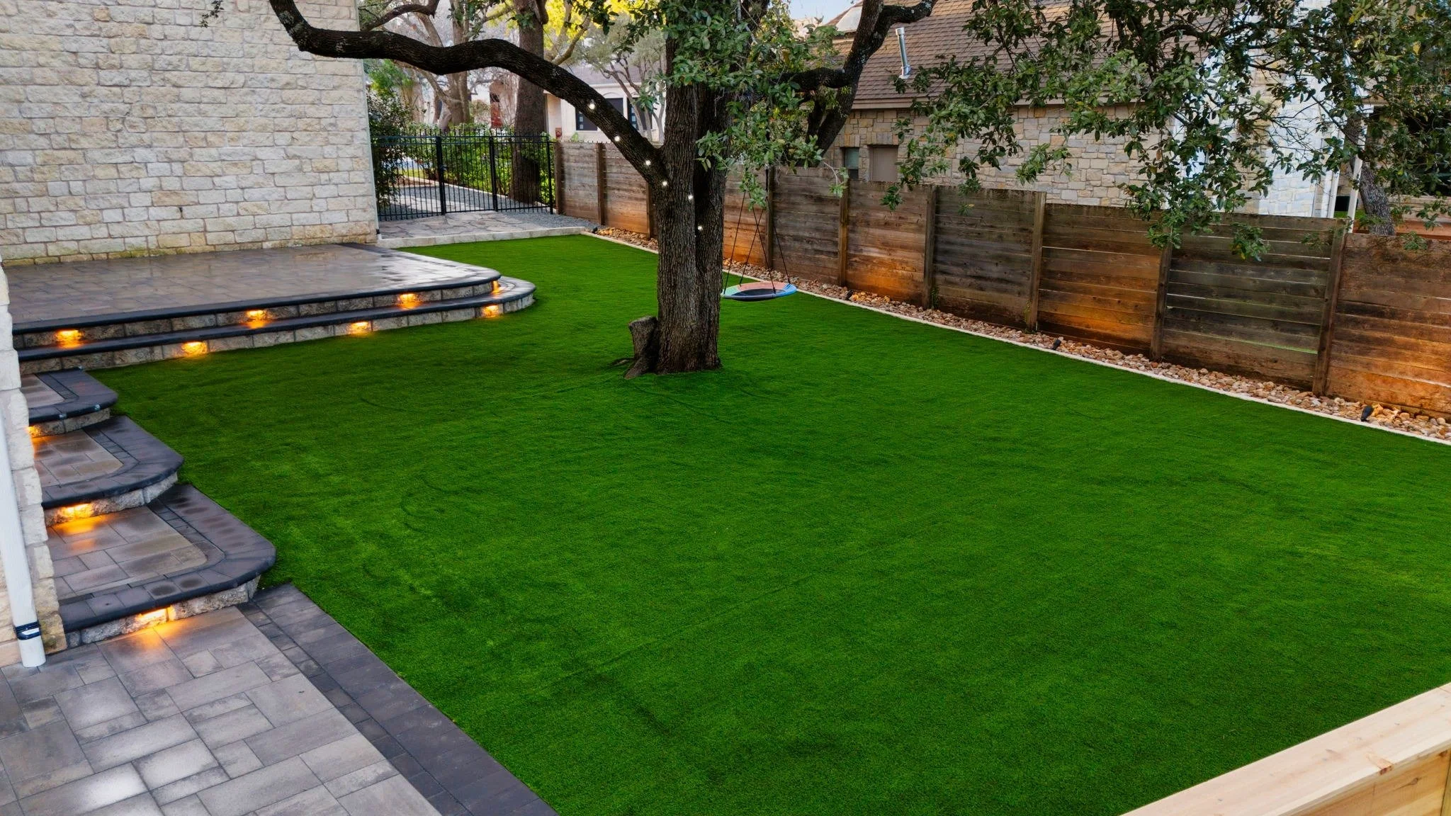 A vibrant backyard after getting a fresh set of artificial turf.