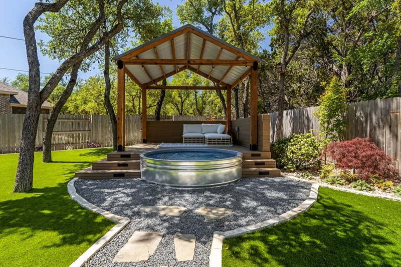Elevated backyard view showing a pergola and shaded seating, a freeze-aware layout for pergolas in Austin landscapes.