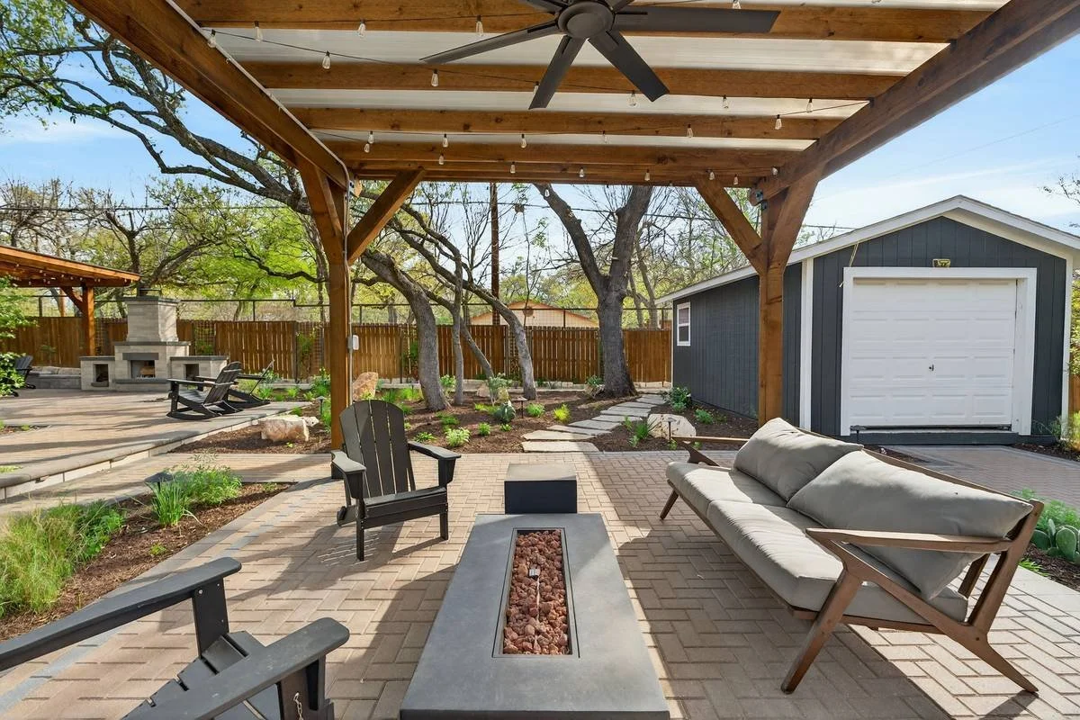 Linear fire table and sofa under a cedar pergola with a ceiling fan — Southern Love Landscaping & Design