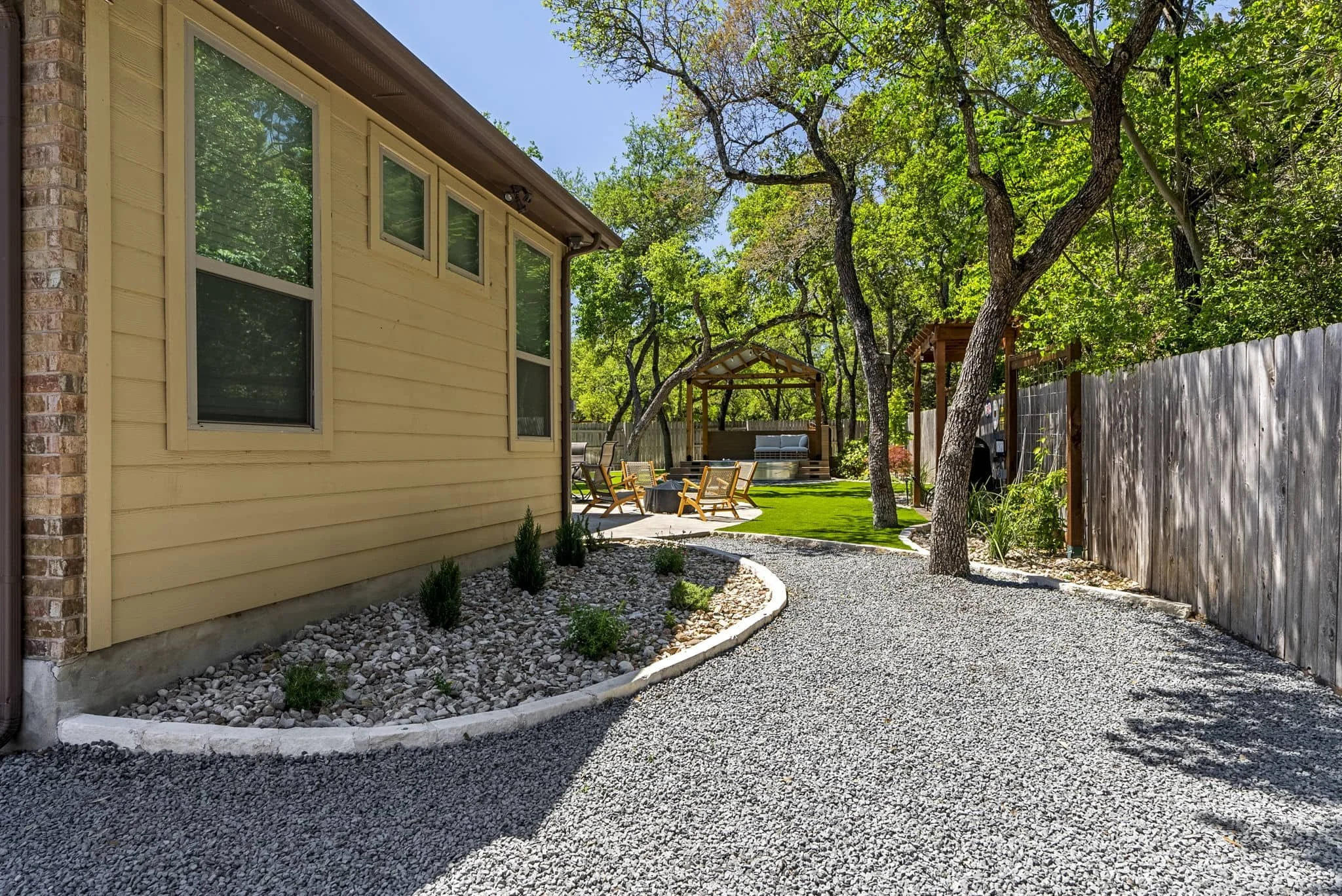 Defined backyard walkways leading to a covered outdoor lounge and putting green — Southern Love