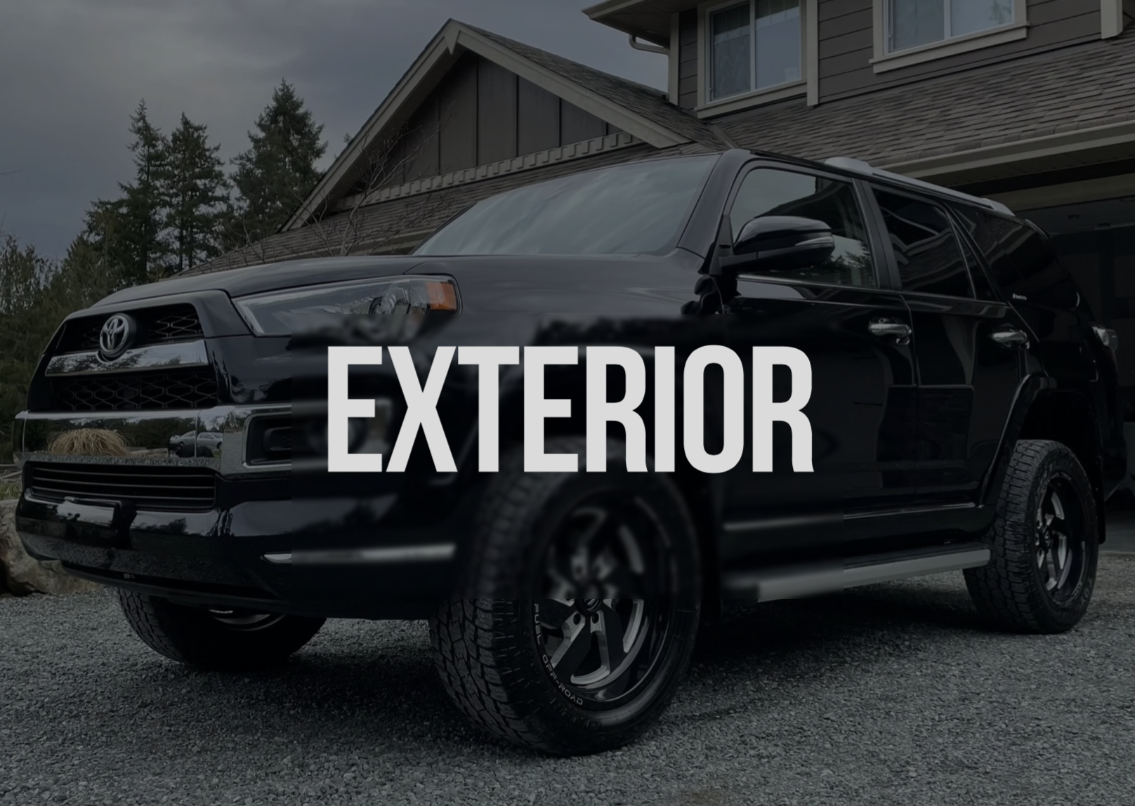 Black SUV parked in front of a house with the word 'EXTERIOR' overlayed.